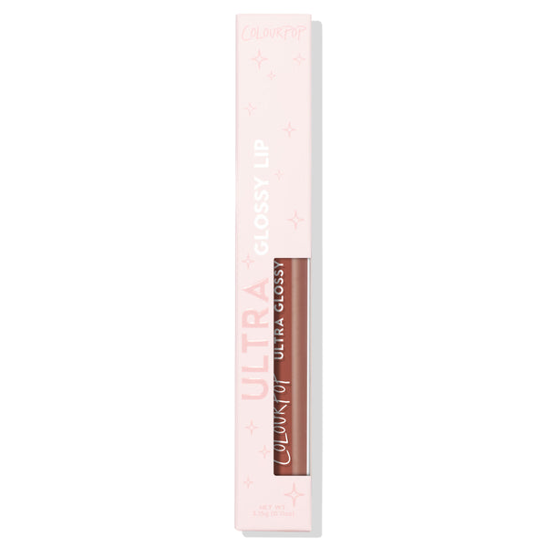 Hit Snooze Ultra Glossy Lip by ColourPop stands upright in a pale pink, star-printed box with a clear window showing the warm brown nude gloss tube on a white background; ColourPop Ultra Glossy Lip, 3.1g (0.11 oz).