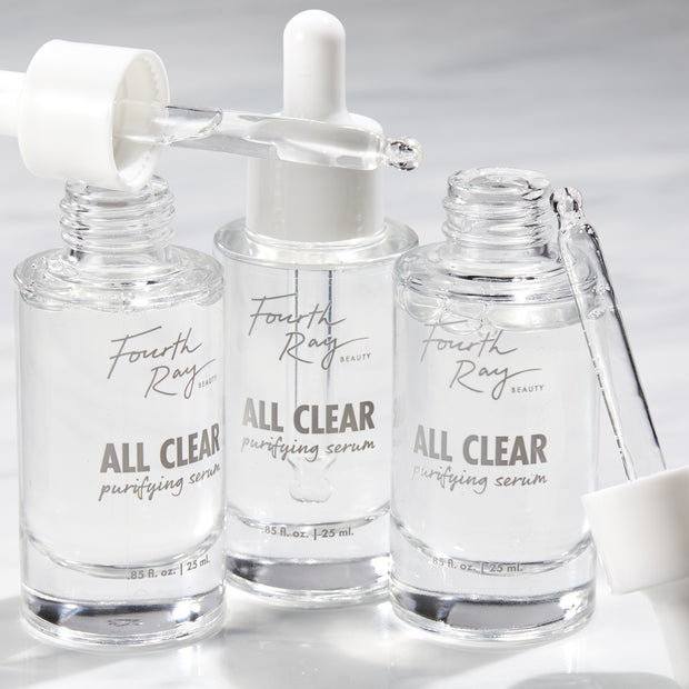 Fourth Ray Beauty All Clear Purifying Serum, a ColourPop Face Serum, three clear 0.85 fl oz (25 mL) glass dropper bottles with pipettes releasing transparent drops on a bright white surface.