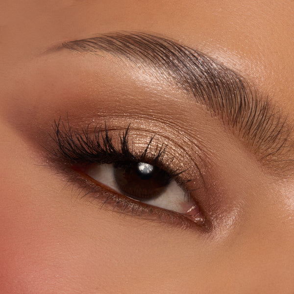 Shimmery champagne and warm mocha eyeshadows sweep across a single eyelid with fluttery lashes, showcasing the Deja Brew ColourPop Shadow Palette; neutral brown tones softly blended on lid and crease for a wearable soft‑glam look in a close-up.