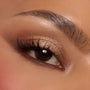 Shimmery champagne and warm mocha eyeshadows sweep across a single eyelid with fluttery lashes, showcasing the Deja Brew ColourPop Shadow Palette; neutral brown tones softly blended on lid and crease for a wearable soft‑glam look in a close-up.
