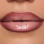 Full lips wear In the Nude Lippie Stix, a ColourPop Lippie Stix shade in pink-beige nude, applied evenly with a glossy satin sheen in a tight studio close-up.