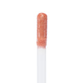 Doe-foot applicator coated in It Girl Ultra Glossy Lip, a peachy-pink shimmer with fine gold flecks, catching light in a macro close-up - ColourPop Ultra Glossy Lip on a clean white background showing its high-shine, creamy texture.