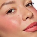 Rosy cheeks and tinted lips wearing ColourPop Lip and Cheek Balm in It’s a Look, showing a dewy, hydrated sheen and soft pink flush; extreme close-up face in studio light highlights smooth texture and natural, buildable color.