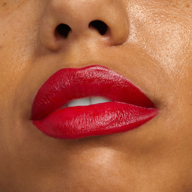 Bold, slightly parted lips wear Va Va Voom, a ColourPop Lippie Stix + Pencil Set, showcasing vibrant classic red color with a creamy satin finish and pencil-defined edges in a clean studio close-up.