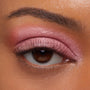 Rosy pink eyelid wearing ColourPop Jelly Much Shadow in Close To You, shimmering in an even metallic wash across the lid and softly blended into the crease, accenting a brown eye with natural lashes and a groomed brow in a studio close-up.