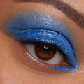 Brown eye wears Stargaze, a ColourPop Jelly Much Shadow, swept across the lid in glossy cobalt blue with subtle silver shimmer, extending to the inner lower lash line for a bold, saturated finish.