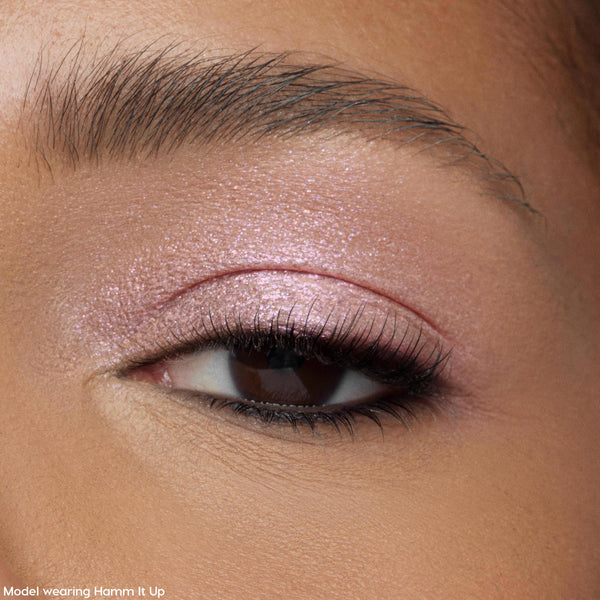 Shimmery pink ColourPop Jelly Much Shadow in Play All Day coats a model’s eyelid, catching light with a wet-look metallic finish; macro close-up shows soft lashes and groomed brow for a wearable, everyday eye makeup look.