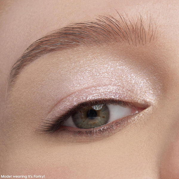 Shimmery eyelid wearing Play All Day Jelly Much Shadow, showing a metallic pale pink wash from ColourPop Jelly Much Shadow, applied across the lid and inner corner, catching light under a groomed brow in an extreme close-up beauty shot.