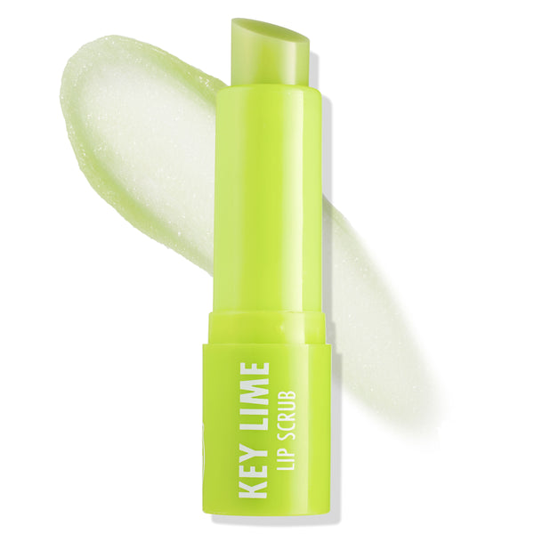 ColourPop Key Lime Lip Scrub stands uncapped with the angled stick exposed, swiping a pale green sugar-grain swatch across a white background, showcasing the neon green tube and exfoliating texture.