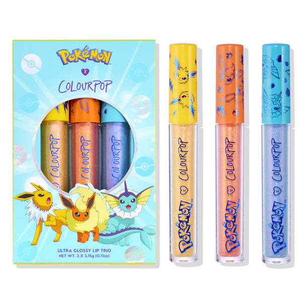 Evolution ColourPop Ultra Glossy Lip trio stands beside its light-blue Pokémon x ColourPop box, decorated with Jolteon, Flareon, and Vaporeon; three shimmery glosses - gold, peach, and icy lavender - sport yellow, orange, and blue character caps.