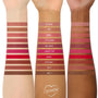 Three arms in light, medium, and deep skin tones display swatches of The Lil Box of Lippie Pencils lip liner shades from Colourpop, arranged in horizontal strips labeled from nude mauves to bright reds and warm browns for comparison.