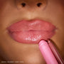 ColourPop So Juicy Plumping Gloss Stick in Pinky Who coating lips for a high-shine pink finish, shown in a close-up with the shimmery pink gloss stick and matching liner held to the lower lip.