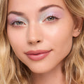 Pastel lavender and icy mint eyeshadow sparkles across lids using the Cute and Feisty ColourPop Shadow Stix, highlighting inner corners and crease; close-up model with soft pink lips and blonde hair shows a fresh, daytime makeup look.