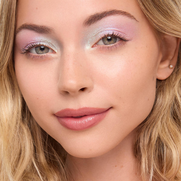 Pastel lavender and icy mint eyeshadow sparkles across lids using the Cute and Feisty ColourPop Shadow Stix, highlighting inner corners and crease; close-up model with soft pink lips and blonde hair shows a fresh, daytime makeup look.