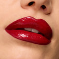 Glossy cherry-red lips showcase Pack Member ColourPop Lip Set, delivering rich pigment and a high-shine finish, captured in an extreme close-up against smooth skin for a bold, vampy look.