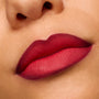 Lips wearing ColourPop Power Pout Lipstick in You Can't Trust Vampires show a deep berry-red gradient with a soft matte, blurred finish in a close-up swatch, highlighting rich pigment and smooth application.