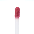 Doe-foot applicator coated in Kitten Ultra Blotted Lip, a soft rosy pink stain, glistening on the plush tip against a white background; ColourPop Ultra Blotted Lip macro showcasing its diffused, blotted formula.