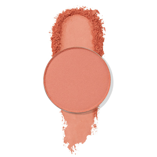 ColourPop Lay Low pressed powder shadow pan sits atop a wide coral-peach matte swatch with softly crushed edges, showcasing the pigment and fine texture against a clean white background.