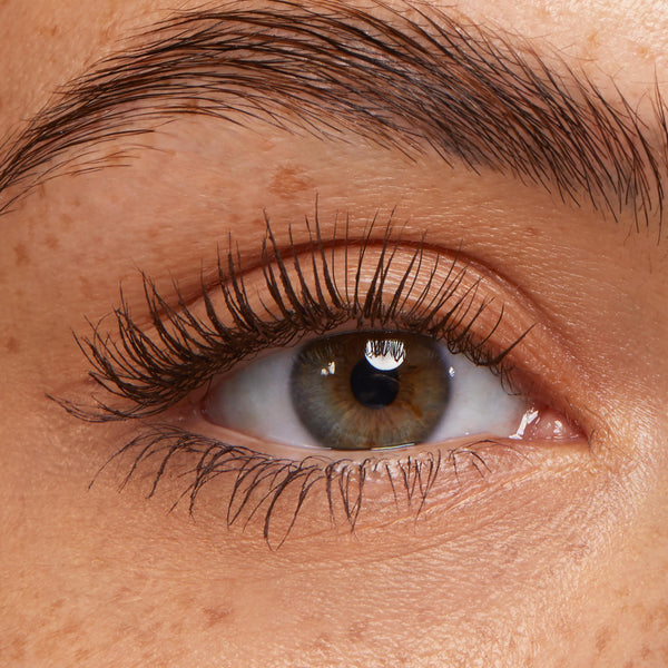Lashes coated in ColourPop Brown Lengthening Mascara, fanned and defined on a close-up hazel eye, showcasing separated length, natural curl, and soft brown pigment against clean lids and a groomed brow.