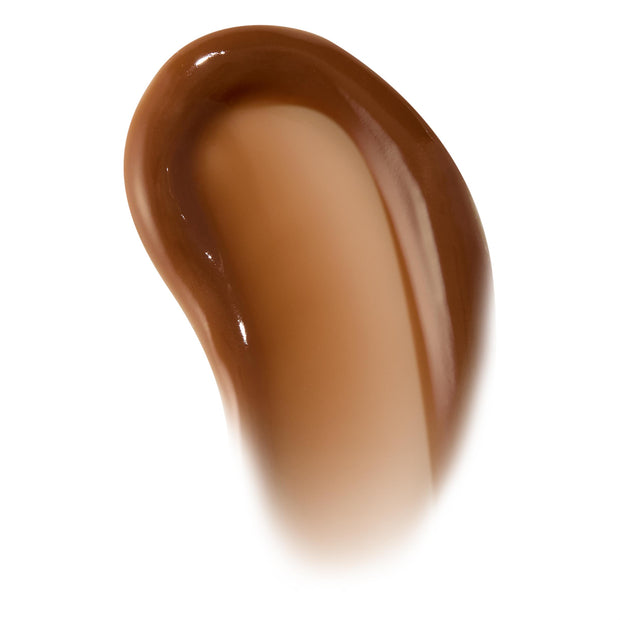 Curved swipe of Chocolate Milkshake ColourPop Lip Mask, a creamy, high-shine caramel-brown swatch on a white background, showcasing the thick glossy texture and tinted finish for accurate shade and texture reference.