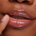 Glossy lips wear You’re a Catch ColourPop Lip Mask, shimmering pink sheen as a fingertip gently applies the product, captured in a tight studio close-up showing a hydrated, plump finish.