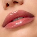 Glossy, hydrated lips showcase Kiss of Darkness from the ColourPop Lip Care Kit, delivering a high-shine, soft pink finish in a macro close-up against smooth, natural skin.