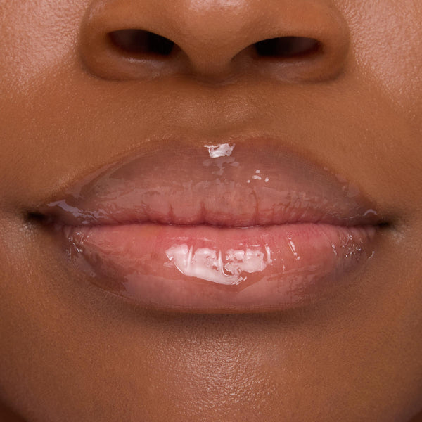 Lips wearing ColourPop Lip Mask in Strawberry Milk, gleaming with a sheer pink, high-shine finish in a tight close-up that emphasizes smooth, hydrated texture.