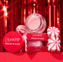 ColourPop Fresh Kiss Candy Cane lip scrub jar and red box showcasing a shimmery pink formula, staged with peppermint candies against a festive red tinsel backdrop; holiday lip exfoliator, 11 g (0.37 oz).