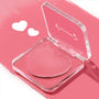 Heart-shaped Lucky U ColourPop Lip and Cheek Balm in an open clear compact, showcasing rosy pink cream; case tilted on a glossy pink background with two white heart doodles, a multitasking lip tint and blush.