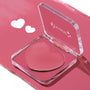 Heart-shaped pink cream in a clear acrylic compact sits open, showcasing the Verified ColourPop Lip and Cheek Balm on a glossy rose background with two white heart graphics, perfect for buildable blush or tinted lip color.