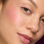 Close-up model cheek and lips wearing ColourPop Lip and Cheek Balm, showing a sheer pink flush and dewy natural finish, highlighting A Shadow of Secrets Collection Full Collection Set for a fresh everyday makeup look.