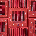 ColourPop Bring The Heat Lippie Pencil set arranged in a flat lay, showcasing creamy lip liners in reds, pinks, and berry tones; boxed and loose pencils surround the main kit on a red background with lips, stars, and lightning graphics.