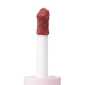 Doe-foot applicator coated in the creamy rosy-nude Culver City shade of ColourPop Liquid Blush, shown in macro close-up with a plush flocked tip rising from a soft pink tube against a clean white background.