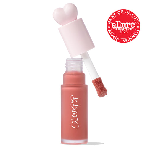 ColourPop Liquid Blush in THX shown open as the doe-foot applicator lifts a rosy peach tint from a frosted bottle with a pink heart cap, COLOURPOP logo visible, on white background with Allure Best of Beauty 2025 award badge.