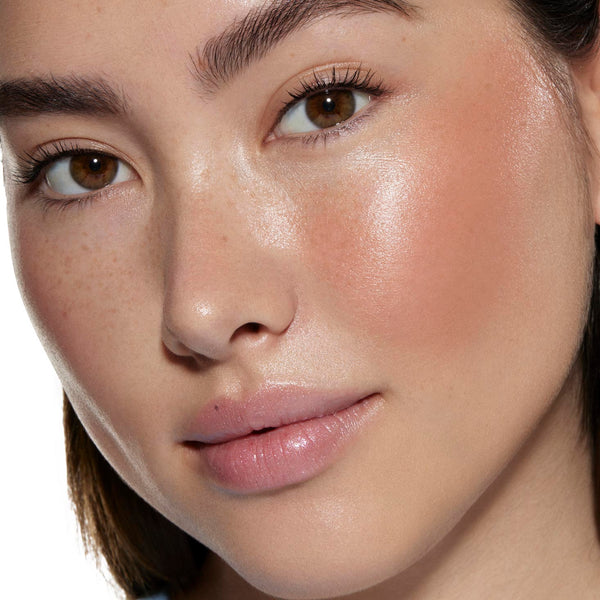 City Walk ColourPop Liquid Blush delivering a dewy peachy-pink flush on a model’s cheek, catching studio light; close-up showcases natural freckles, smooth skin, and the blendable liquid formula’s radiant, long-wear glow.