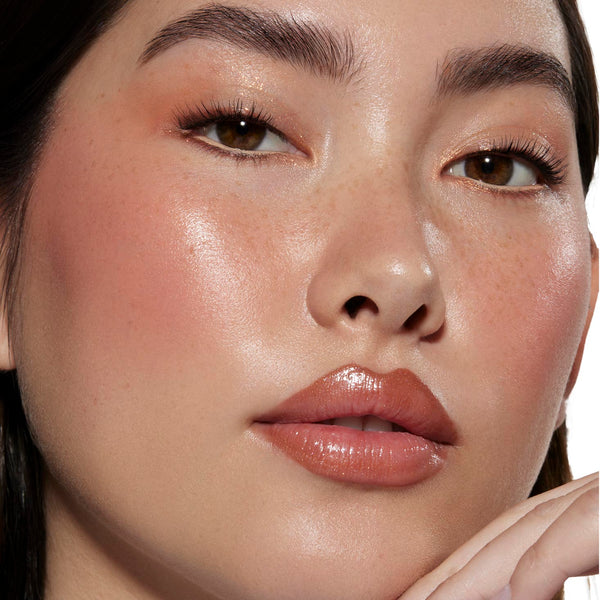 Perfect Peach ColourPop Liquid Blush glowing on model’s cheeks, creating a dewy peach flush with soft shimmer; paired with warm peach eyeshadow and glossy nude lips in a studio close-up for a fresh, natural finish.