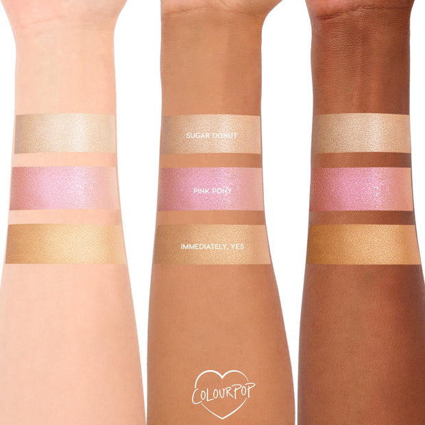Pink Pony ColourPop Liquid Highlighter swatched on three arms, showing a luminous pink pearl sheen between shades Sugar Donut and Immediately, Yes; reflective shimmer across light, medium, and deep skin tones for easy shade comparison.