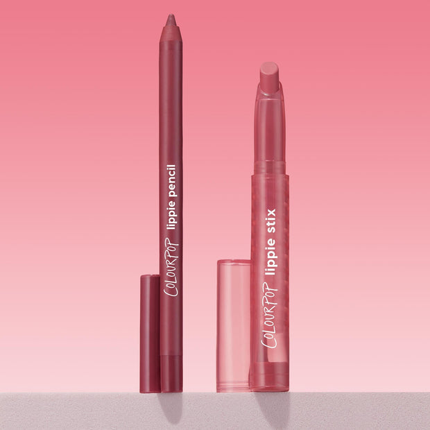 ColourPop Got Pink? Lippie Stix + Pencil Set showing a rosy mauve lip pencil and matching Lippie Stix standing uncapped with translucent pink caps beside them on a light shelf against a pink gradient background; ColourPop Lippie Stix + Pencil Set.