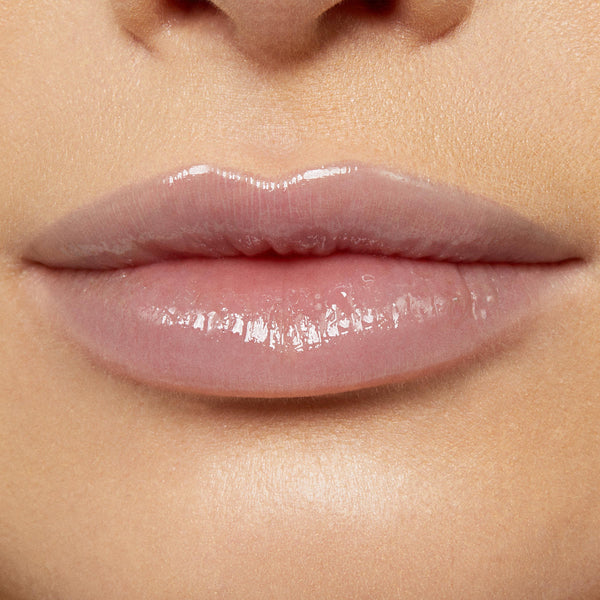 Glossy lips wearing Team Edward Lux Lip Oil reflect a high-shine, sheer pink finish, captured in a studio close-up to showcase the smooth, hydrated look of ColourPop Lux Lip Oil on natural lips.