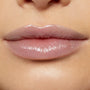 Glossy lips wearing Team Edward Lux Lip Oil reflect a high-shine, sheer pink finish, captured in a studio close-up to showcase the smooth, hydrated look of ColourPop Lux Lip Oil on natural lips.
