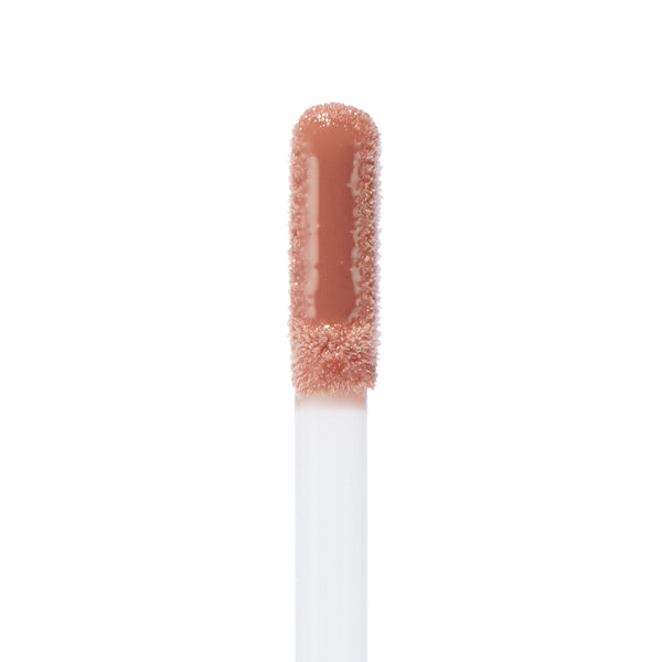 Doe-foot applicator coated in Lynx Ultra Glossy Lip, a warm nude peach shade, showcasing the high-shine ColourPop Ultra Glossy Lip formula in a macro close-up against a clean white background.