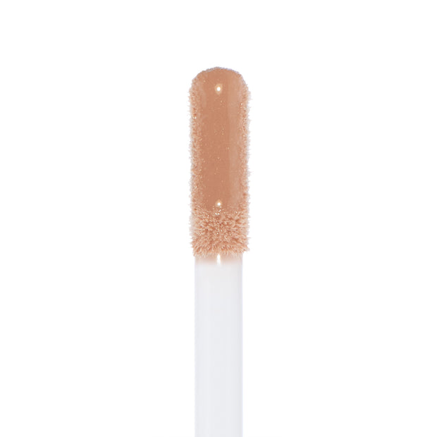Doe-foot applicator coated in Major Throwback Ultra Glossy Lip, a warm nude-beige gloss with fine shimmer reflecting light for a high-shine finish, shown in a clean macro on white; ColourPop Ultra Glossy Lip.