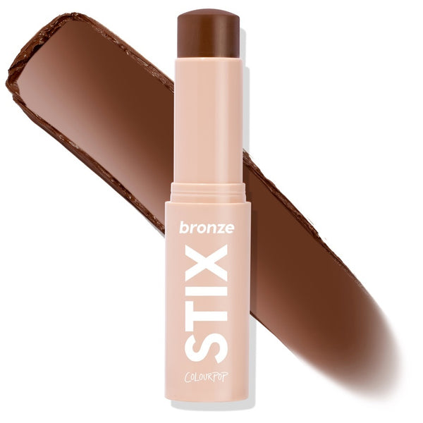 ColourPop Bronzer Stix Manhattan Beach, a twist-up cream bronzer stick in a blush-nude tube labeled STIX, uncapped to show a deep chocolate shade, with a broad diagonal swatch behind it on a white studio background.