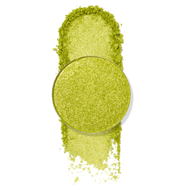 Mary Jane ColourPop Pressed Powder Shadow pan showcases a bright lime-green metallic shade with gold shimmer, shown crushed and swatched with loose pigment around the round pan on a white background to highlight sparkle and payoff.