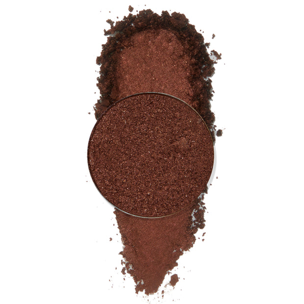 Material Girl ColourPop Pressed Powder Shadow pan spills crushed metallic deep copper-brown shimmer into a soft swatch, with the round refill centered on a clean white background.