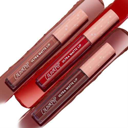 ColourPop Ultra Matte Lip Matte Babe trio displays three liquid lipsticks - nude mauve, vivid red, and deep brick - arranged diagonally over matching swatches, with peach star-print caps and clear tubes showing full-coverage ultra-matte pigment.