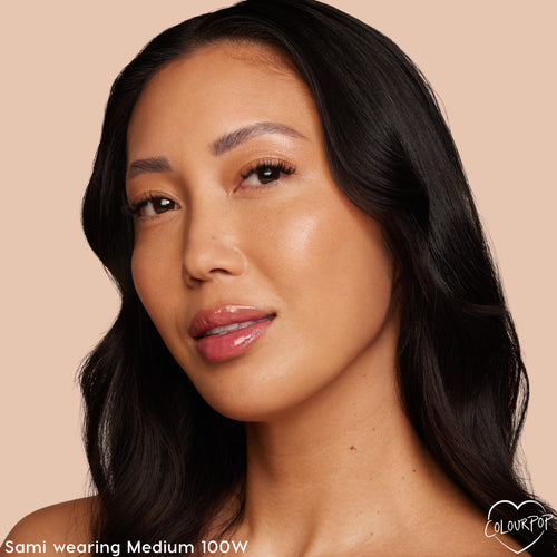 ColourPop Pretty Fresh Creamy Concealer in Medium 100 W evening skin tone on a model’s face, showing a warm undertone and natural dewy coverage in a close-up portrait against a soft beige background.