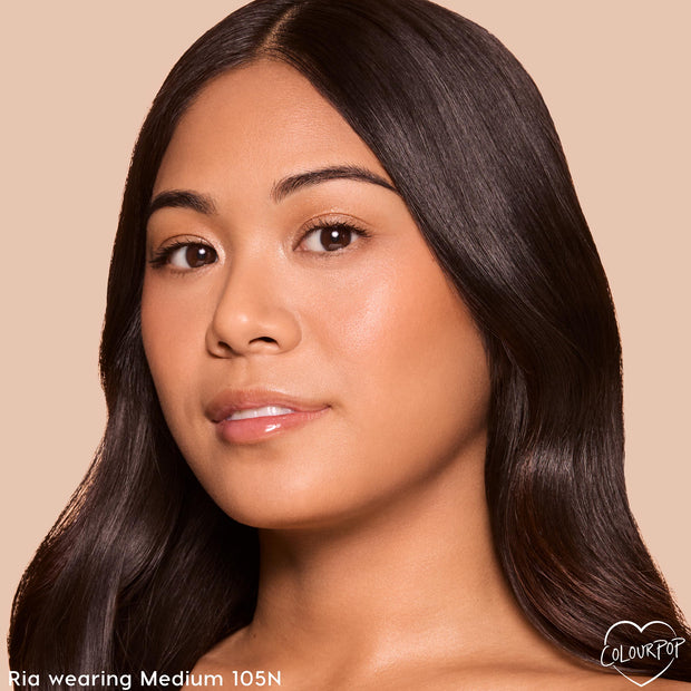 Model wearing ColourPop Pretty Fresh Creamy Concealer in Medium 105 N, showcasing smooth under‑eye coverage and an even, radiant complexion in a close-up studio shot against a beige background.