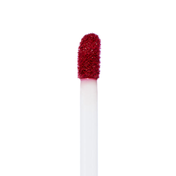 Doe-foot applicator coated in Melonade, a bold watermelon-red Ultra Matte Lip, showing velvety pigment and texture, standing upright against a clean white background - ColourPop Ultra Matte Lip product macro for precise color detail.