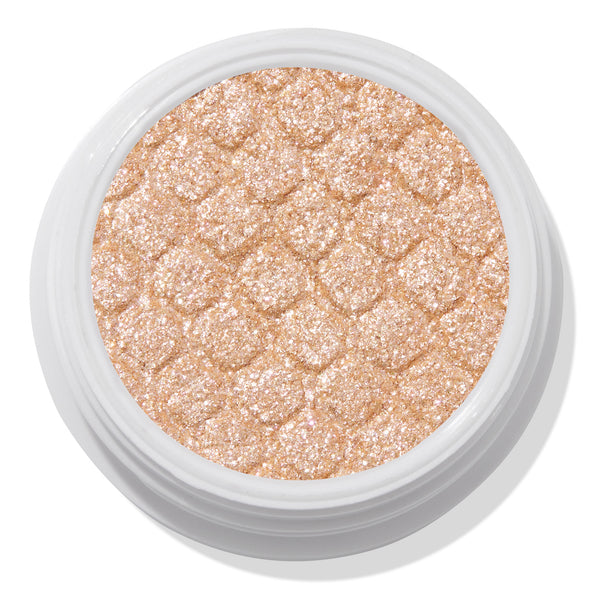 Mighty Morphin’ ColourPop Super Shock Shadow shimmers in a metallic champagne-gold, pressed with a quilted texture in an open white pot, close-up on a white background.